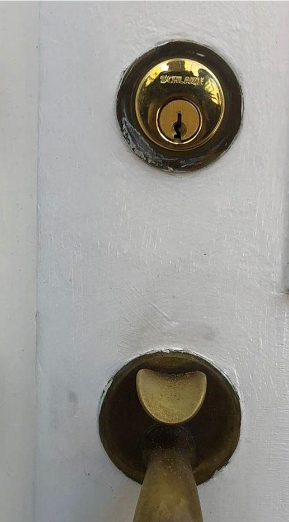 locksmith services residential locksmith door lock door lock installation emergency locksmith lock repair Close-up of a Schlage deadbolt lock and door handle on a white door, highlighting security features for residential door upgrades.