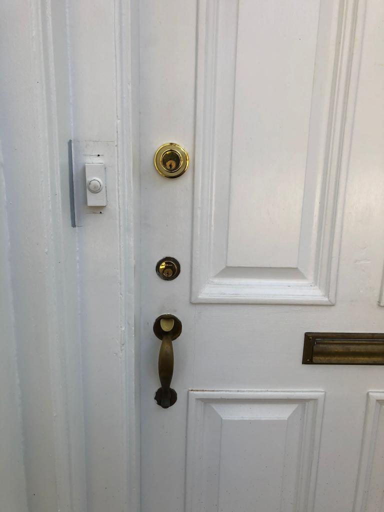 emergency locksmith lock repair locksmith services residential locksmith door lock door lock installation Residential door with a brass deadbolt lock, door handle, and doorbell, emphasizing security and door hardware for homes in Washington, DC.