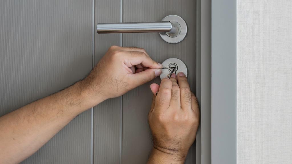 A locksmith picking a stuck door lock