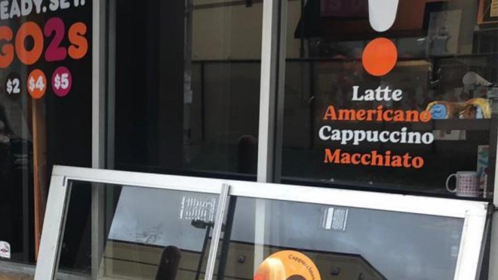 Aluminum glass door installation in front of a café, featuring menu items like latte, americano, cappuccino, and macchiato on the window.