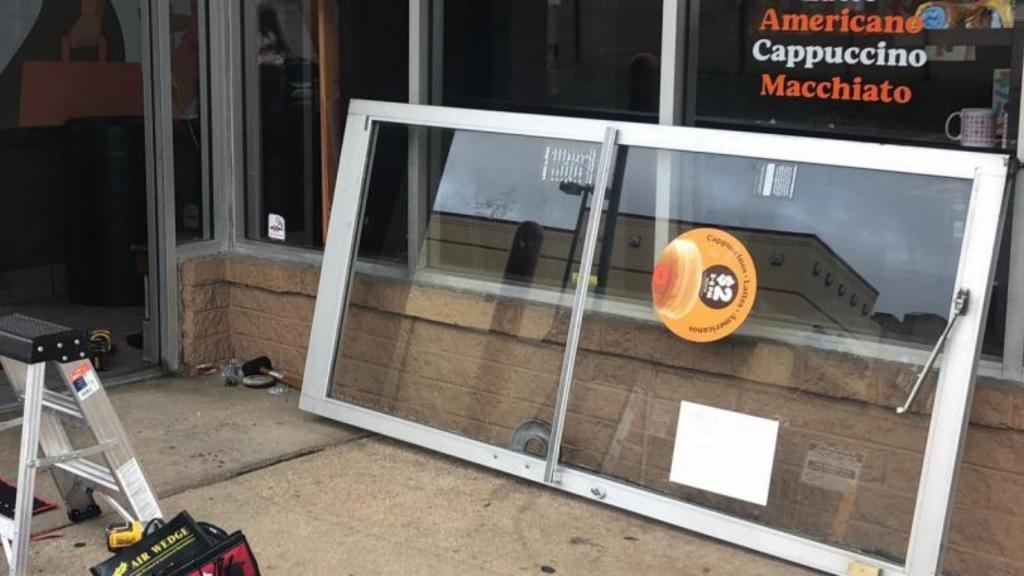 Aluminum glass commercial door installation outside a food establishment, tools and ladder visible, showcasing repair process by MacArthur Locks & Doors in Arlington, VA.