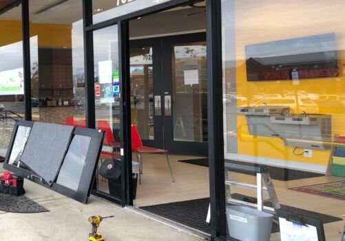 Commercial aluminum glass door repair in Alexandria, VA, showcasing an open storefront with tools and equipment for door installation and repair.