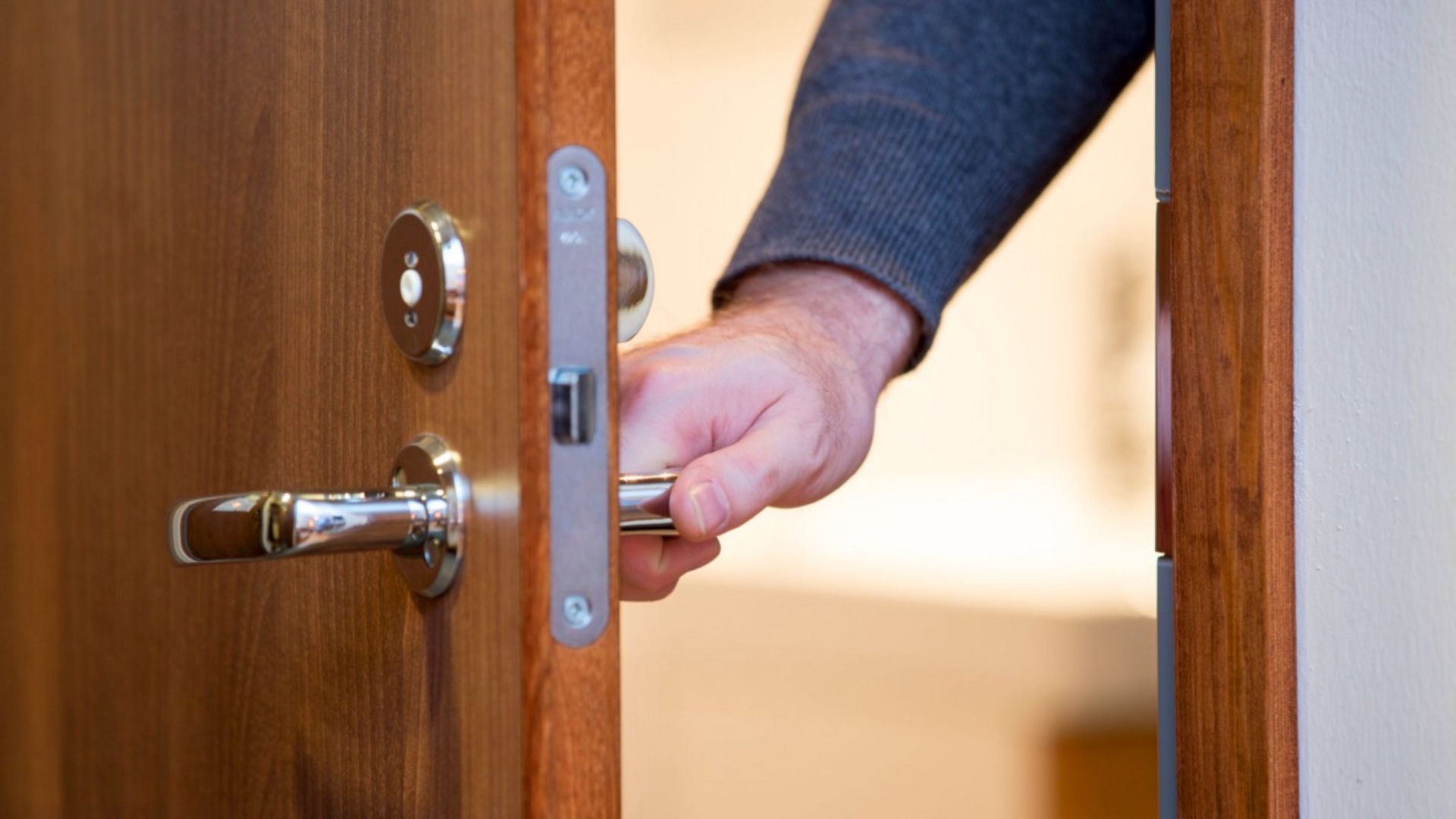 A man opening a door with a mortise lock