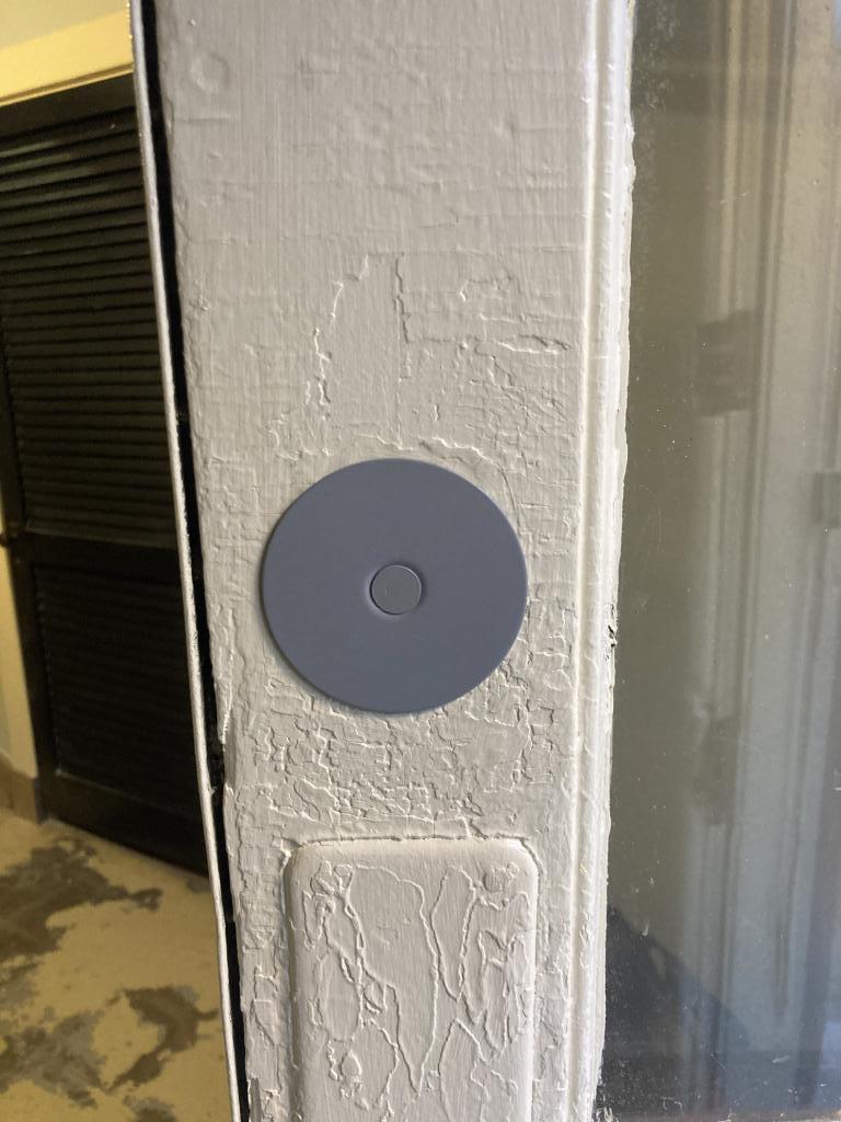 Door lock installation featuring a modern round electronic lock on a white door frame, emphasizing residential security enhancements by MacArthur Locks & Doors.