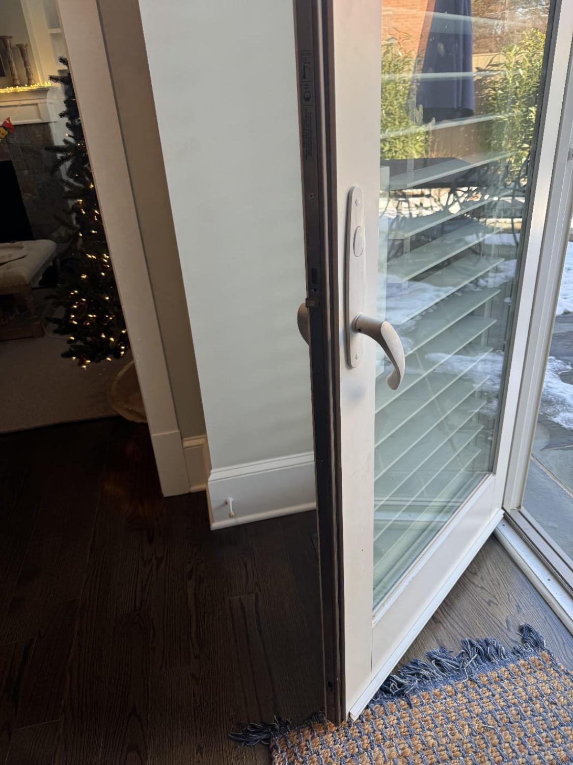 Exterior glass patio door with loose handle and visible locking mechanism, illustrating front door handleset repair issues in Arlington, VA.